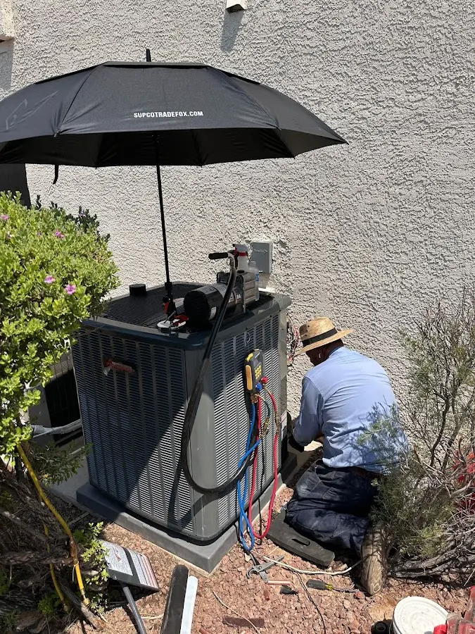 HVAC technician performing outdoor AC maintenance in East Rancho Dominguez
